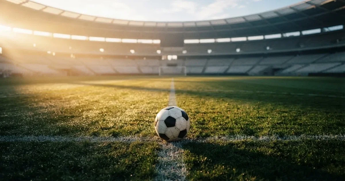 A ball on the centre spot of a grass pitch in morning light